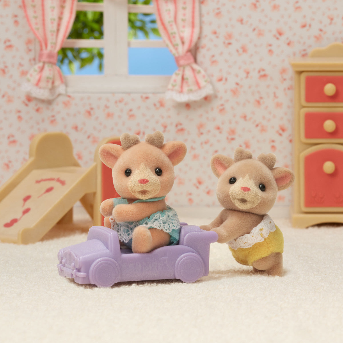 Reindeer Twins sitting and crawling figures with purple pushcart in a cozy dollhouse room setting for ages 3+