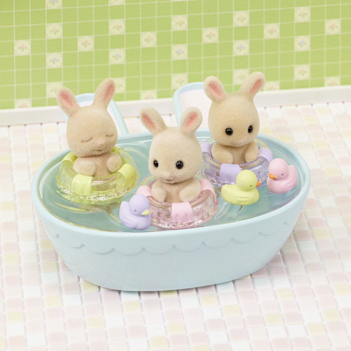 Triplets Bathtime Set with three Milk Rabbit triplets floating in a blue tub with pastel duck bath toys.
