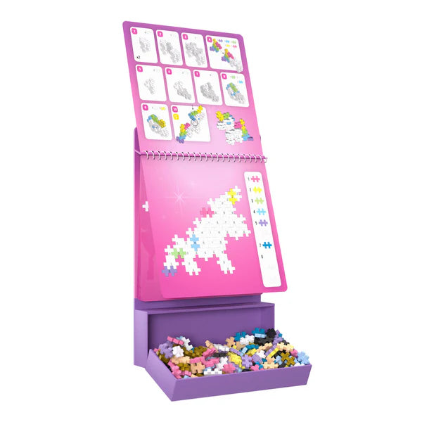 Plus Plus Activity Pad | Fairy Tale showing a unicorn puzzle build with colorful pieces and storage box below.