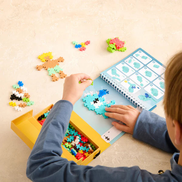 Child assembling colorful ocean shapes using Plus Plus Activity Pad | Ocean with flippable pad and storage box.