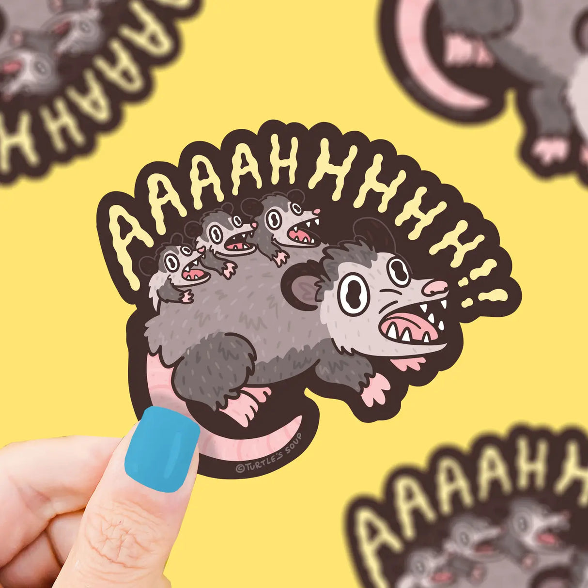 Screaming Crazy Opossum Vinyl Sticker showing a cartoon opossum with open mouth and text Aaaahhh on a yellow background.