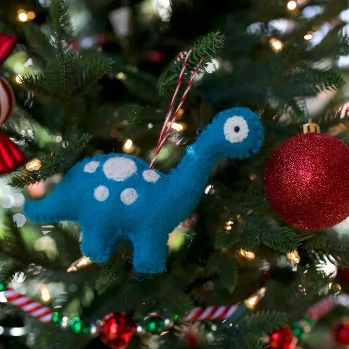 Brachiosaurus Dino Felt Ornament in blue and white wool hanging on a Christmas tree with lights and red ornaments.