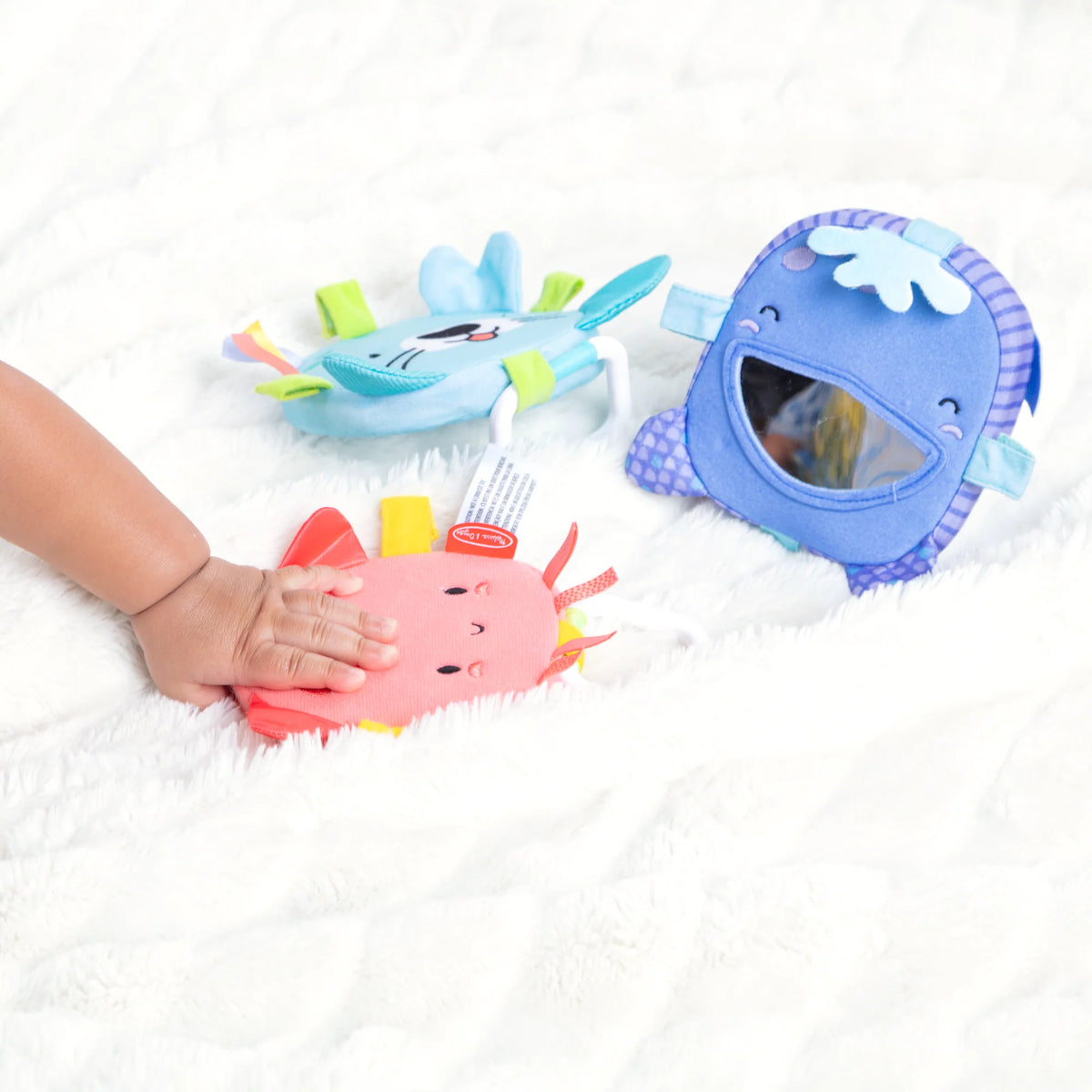 Ocean Waves Bounce Back Links sensory ocean themed baby toys on a soft white blanket