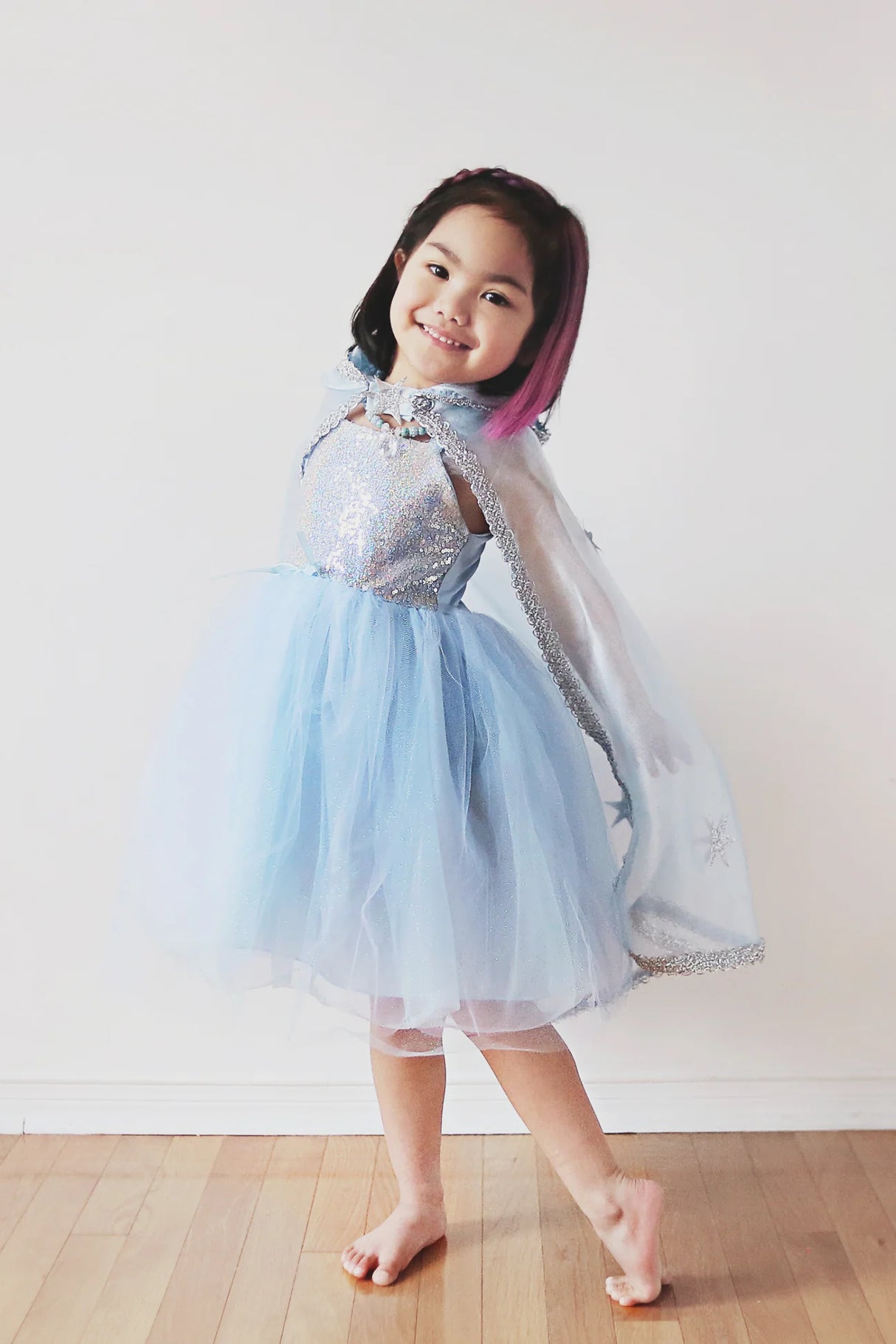 Child wearing Snow Queen Cape | Size 5-6 made of blue crystal organza with silver glitter stars and hood.