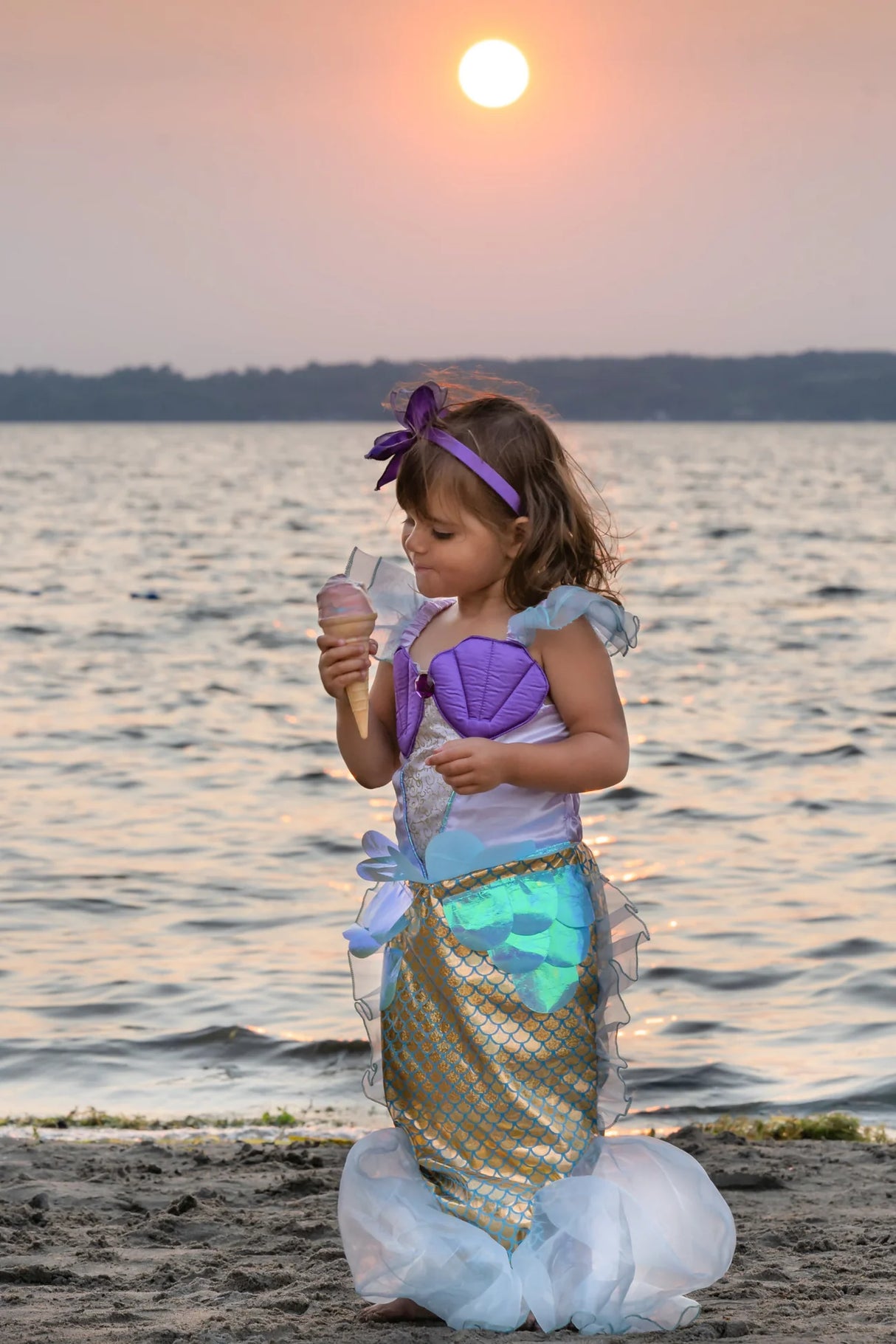 Little girl wearing Mermaid Dress & Headband Lilac size 5-6 eating ice cream by the sunset beach.
