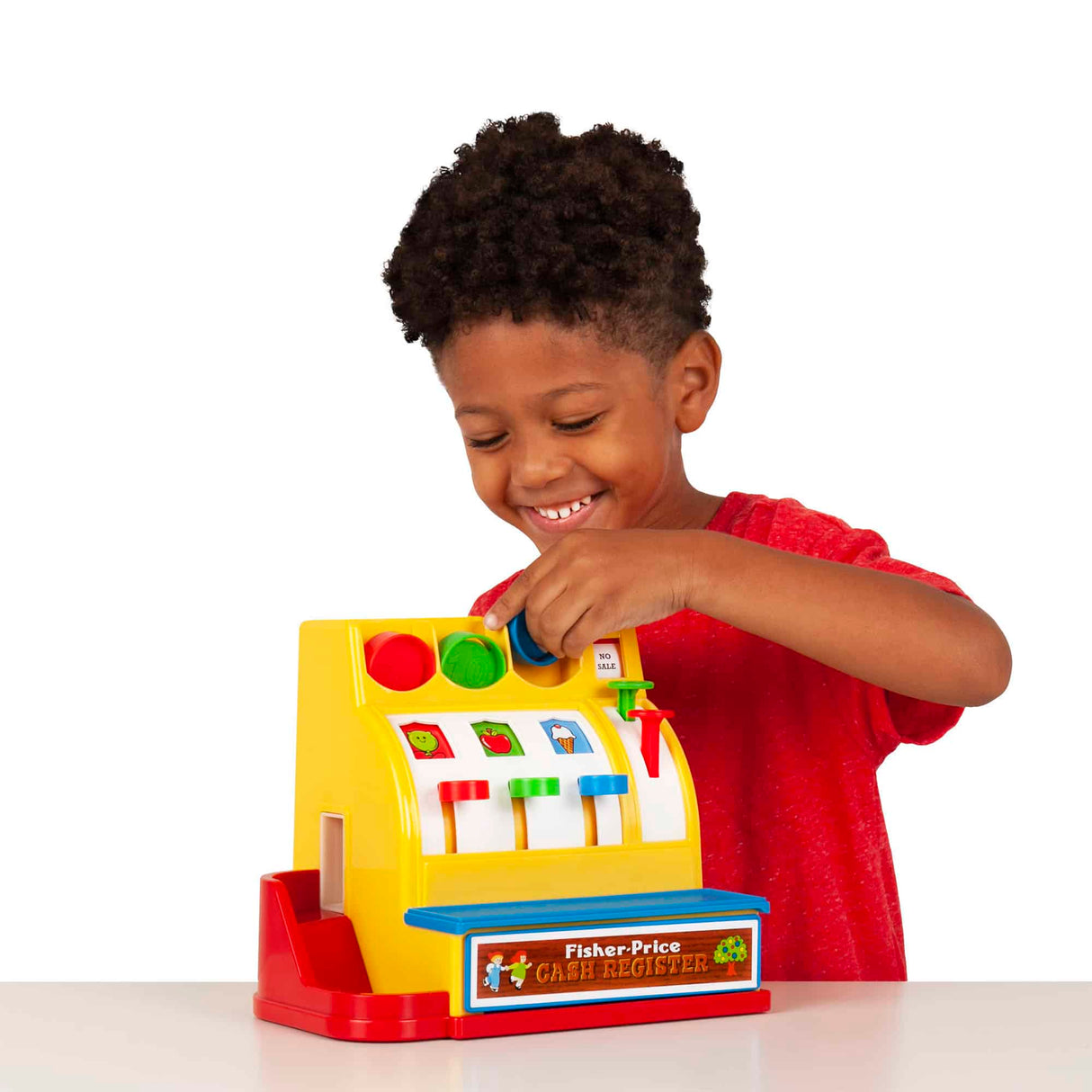 Child playing with a yellow and red Fisher Price Cash Register with colorful coins and turning crank toy.