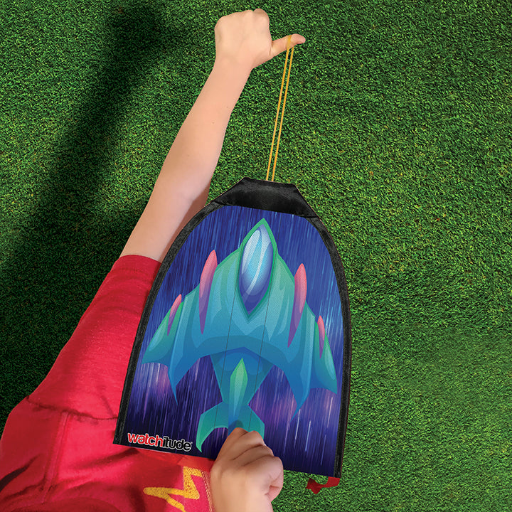 Child holding a colorful rubber band rocket kite ready to launch on a sunny day over green grass