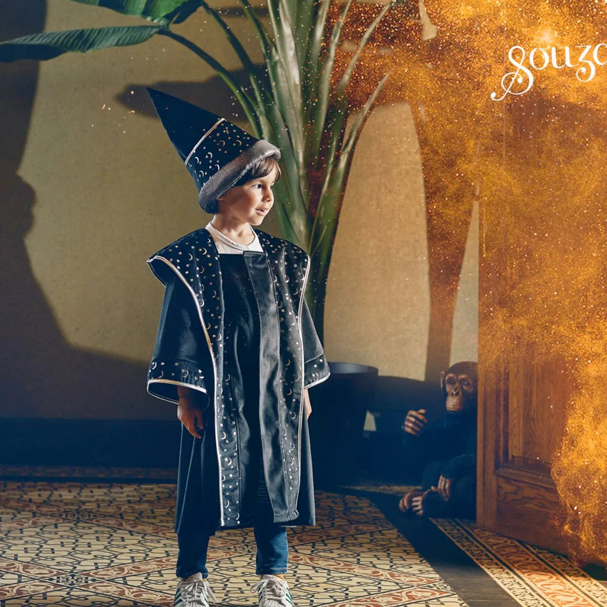 Child wearing a black wizard hat decorated with silver stars and moons for magical imaginative play