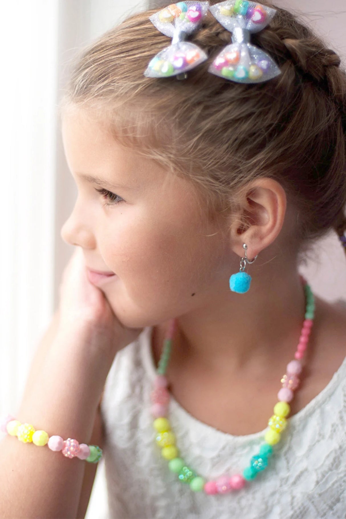 Young girl wearing the Vividly Vibrant Necklace & Bracelet Set with colorful yellow, green, and pink beads.