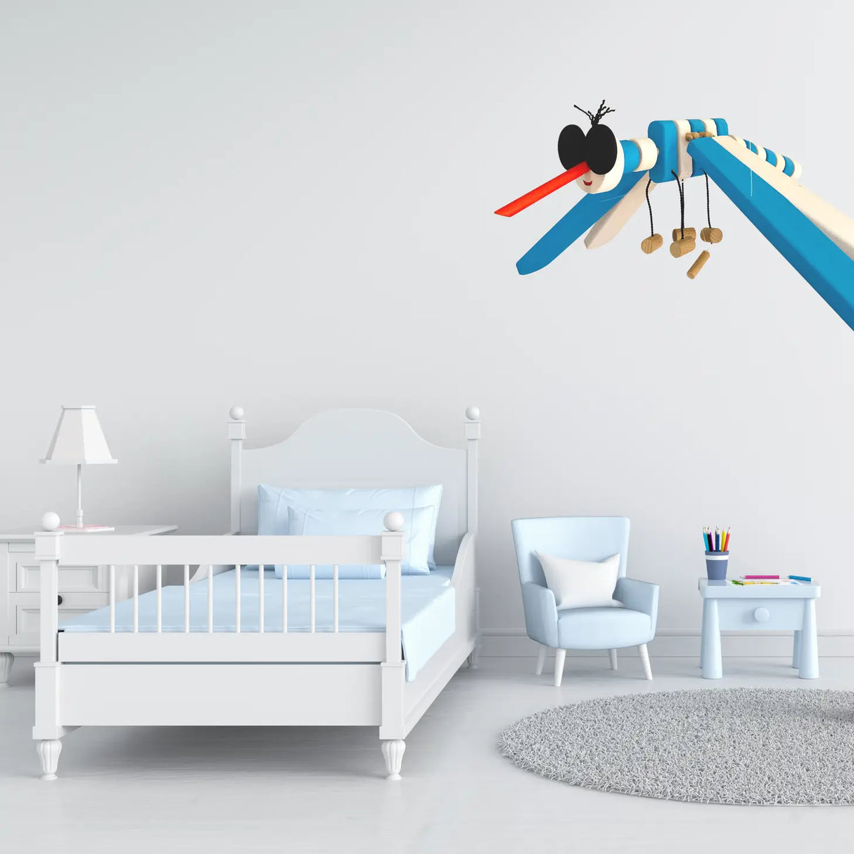 Wooden Mobile Flying Mosquito hanging in a bright nursery with white furniture and soft blue accents.