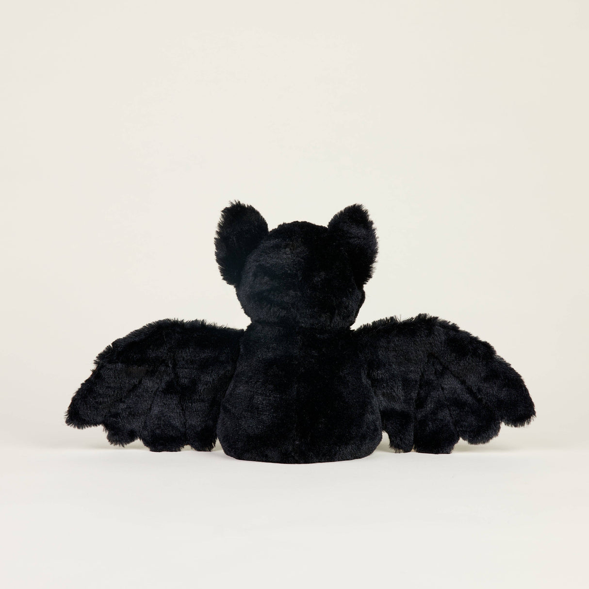 Back view of a soft black plush bat with outstretched wings designed for soothing warmth and comfort.