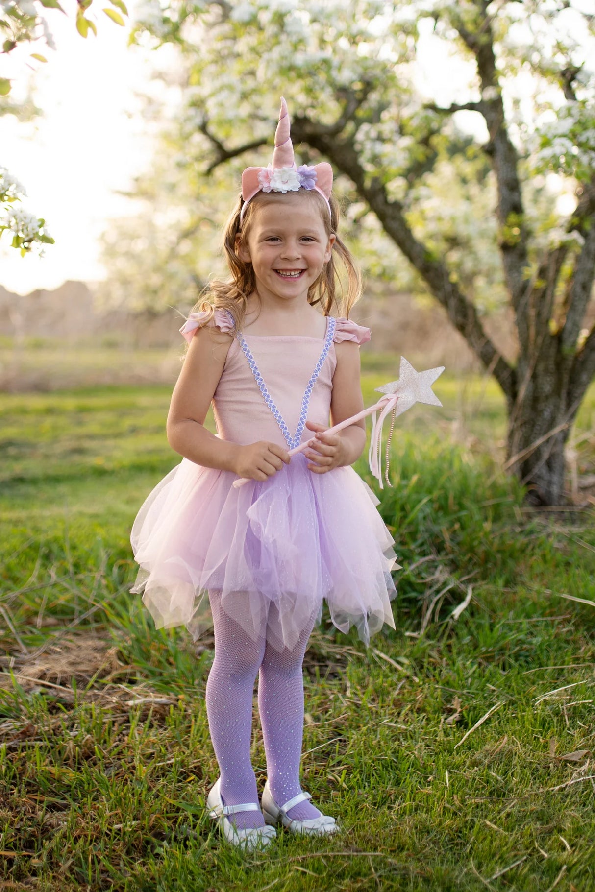 Pink Shimmer Unicorn Dress & Headband size 3-4 with ruffled sleeves, tulle skirt, and floral unicorn headband worn by smiling girl.