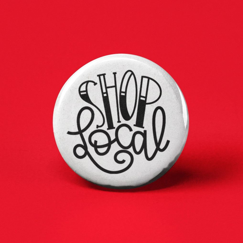 Round white button pin with black stylized "Shop Local" text on bright red background