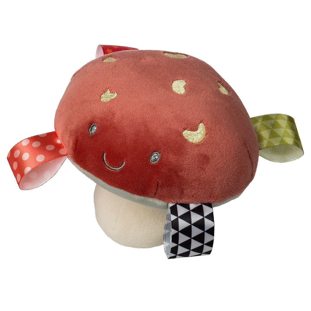 Taggies Fun Guys Mushroom Rattle with soft texture, embroidered face, and colorful sensory ribbons for baby playtime.