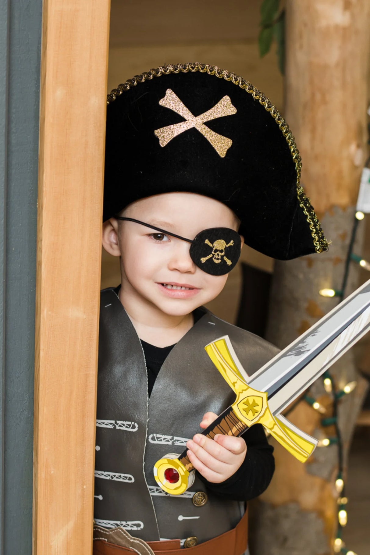 Child dressed as pirate wearing a Pirate Eye Patch and hat holding a toy sword for imaginative play.