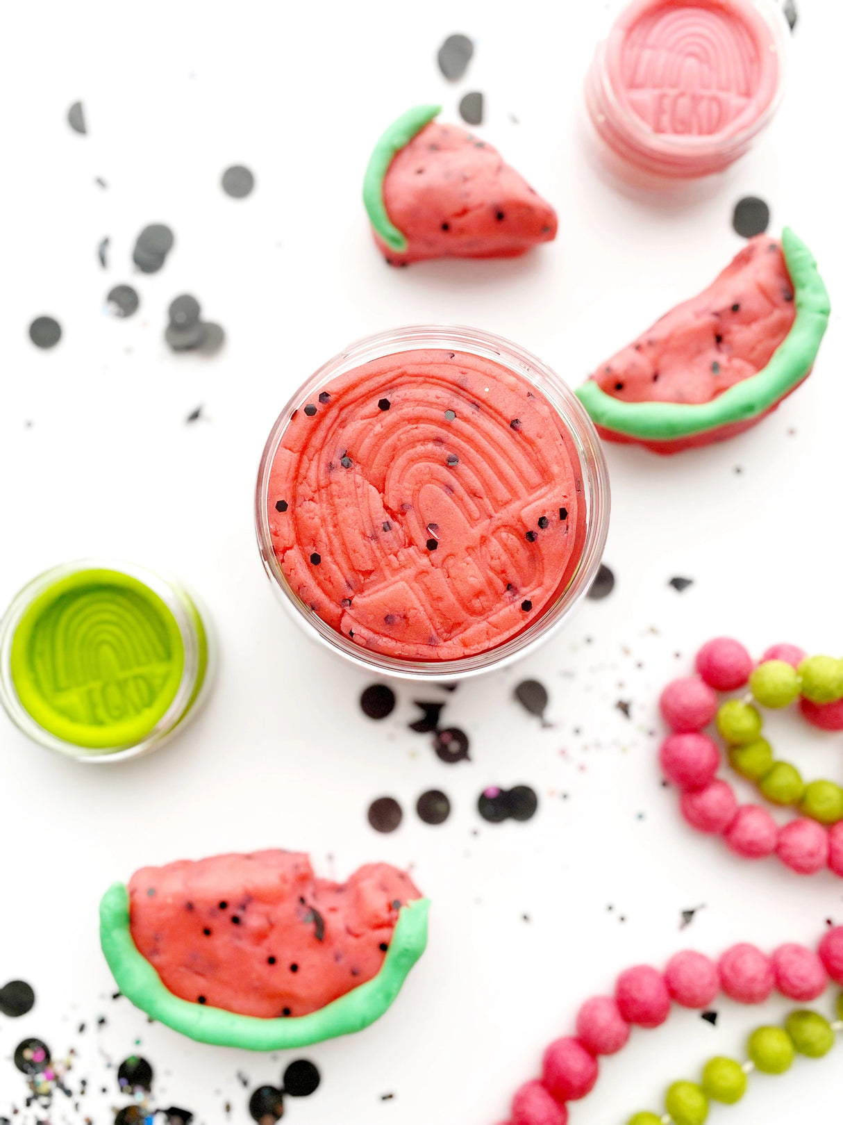 KidDough | Watermelon Slice with black glitter seeds modeled as watermelon wedges in open containers.