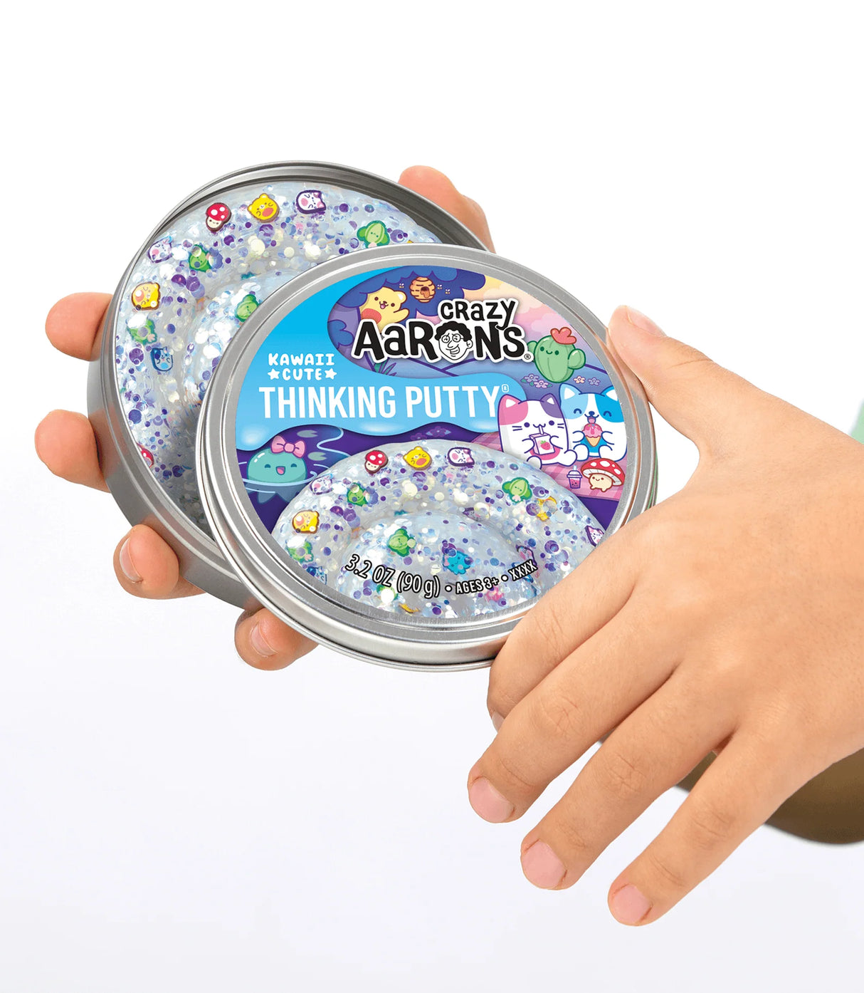 Hand holding open tin of Trendsetters Kawaii Cute Thinking Putty with colorful sparkly design inside.