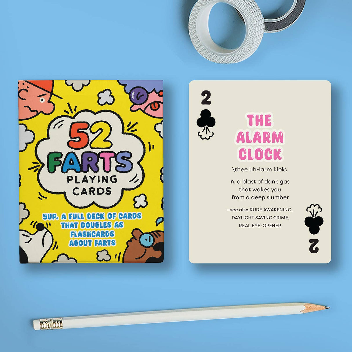 Box of 52 colorful fart-themed playing cards with a humorous flashcard explaining "The Alarm Clock" fart term next to a pencil