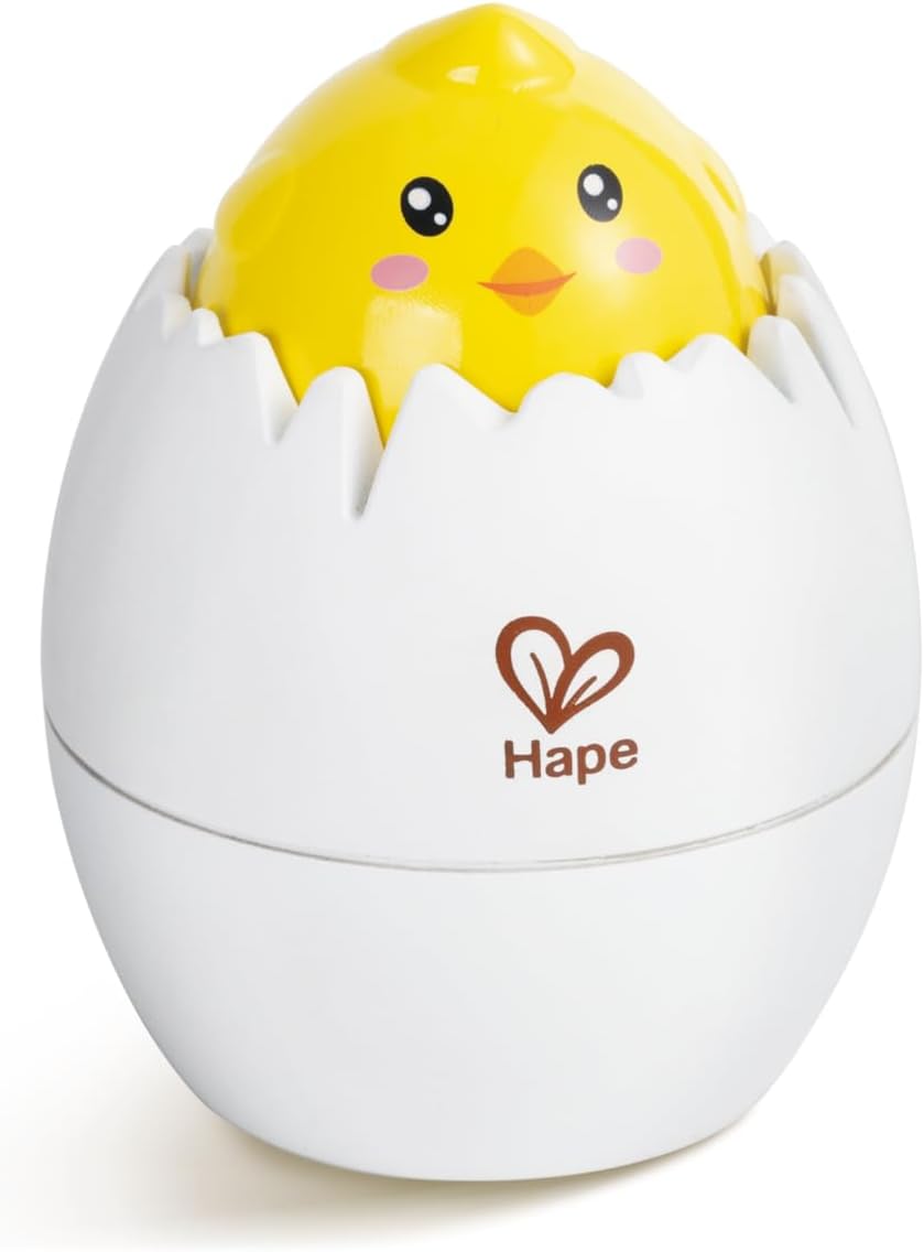 Yellow chick toy peeking out of white egg shell designed to engage babies and develop motor skills