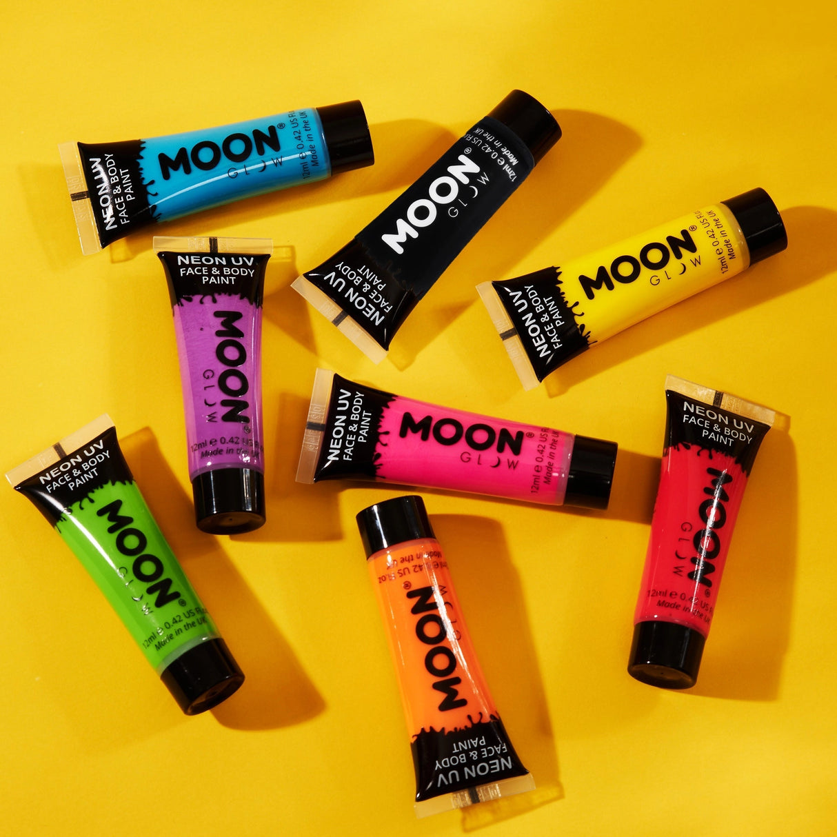 Face & Body Paints| Neon UV Glow tubes in vibrant colors arranged on a yellow background for creative body art.