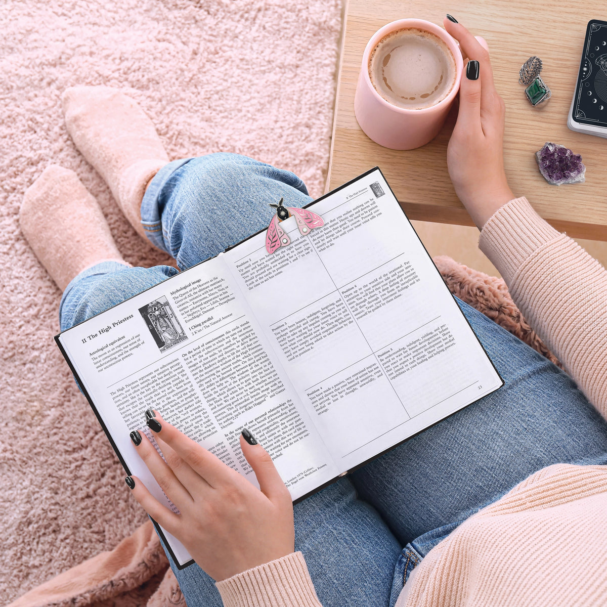 Moth Marks Bookmarks tucked into an open book beside a cup of coffee while reading