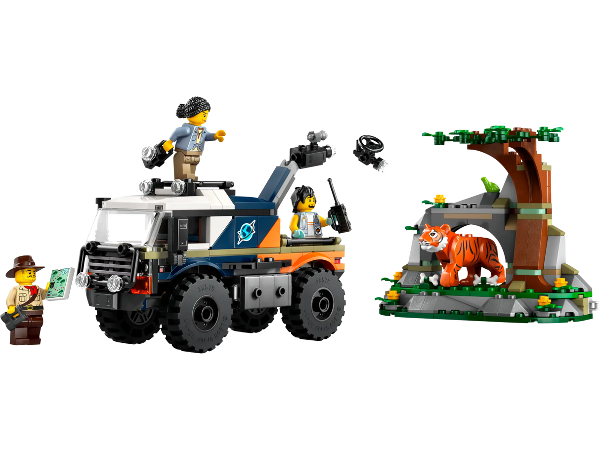 Toy off-road truck with rugged tires and movable camera alongside jungle scene with tiger and tree figures