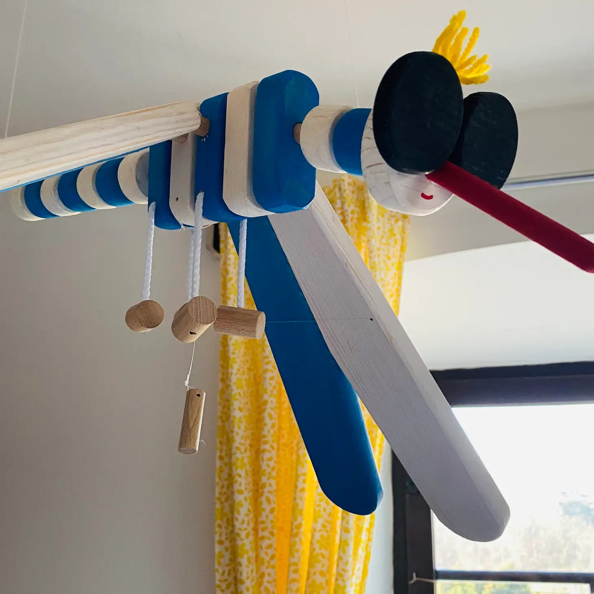 Wooden Mobile Flying Mosquito kinetic nursery decor made from European wood, hanging on nylon strings with a long red beak.