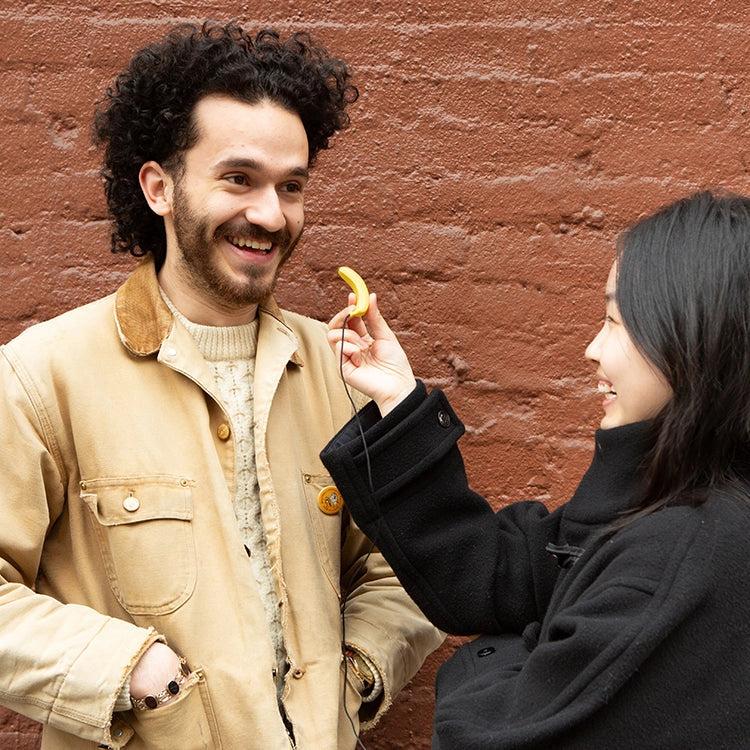 Mini Banana Microphone held up for a playful interview between two smiling people