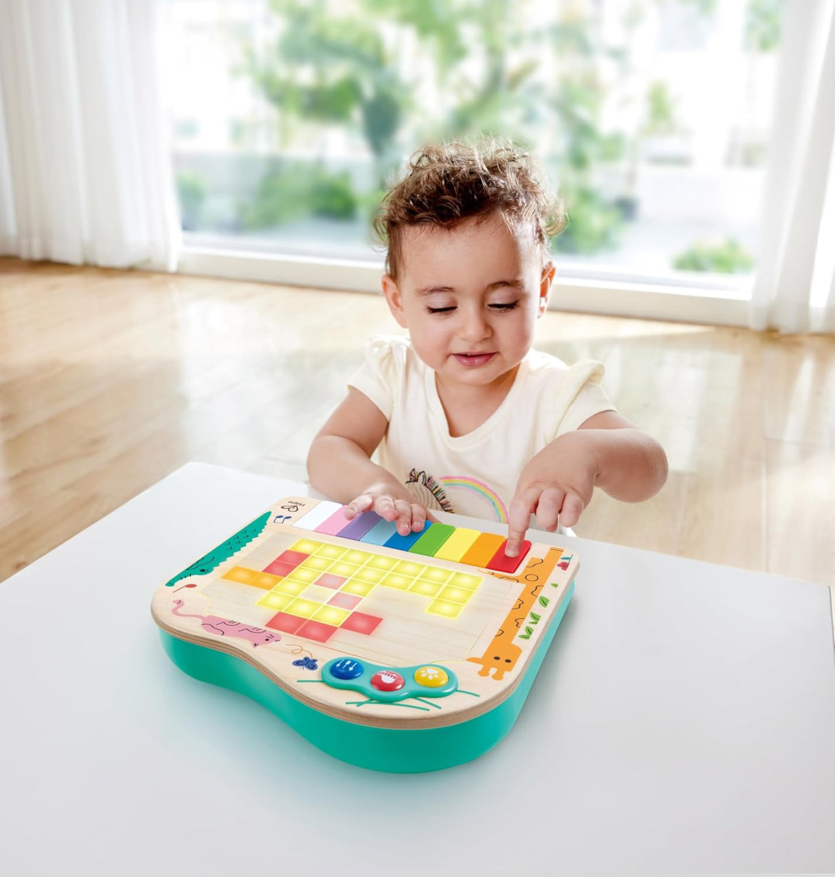 Toddler playing with the colorful Hape Dynamic Pixel Piano featuring interactive lights and engaging play modes