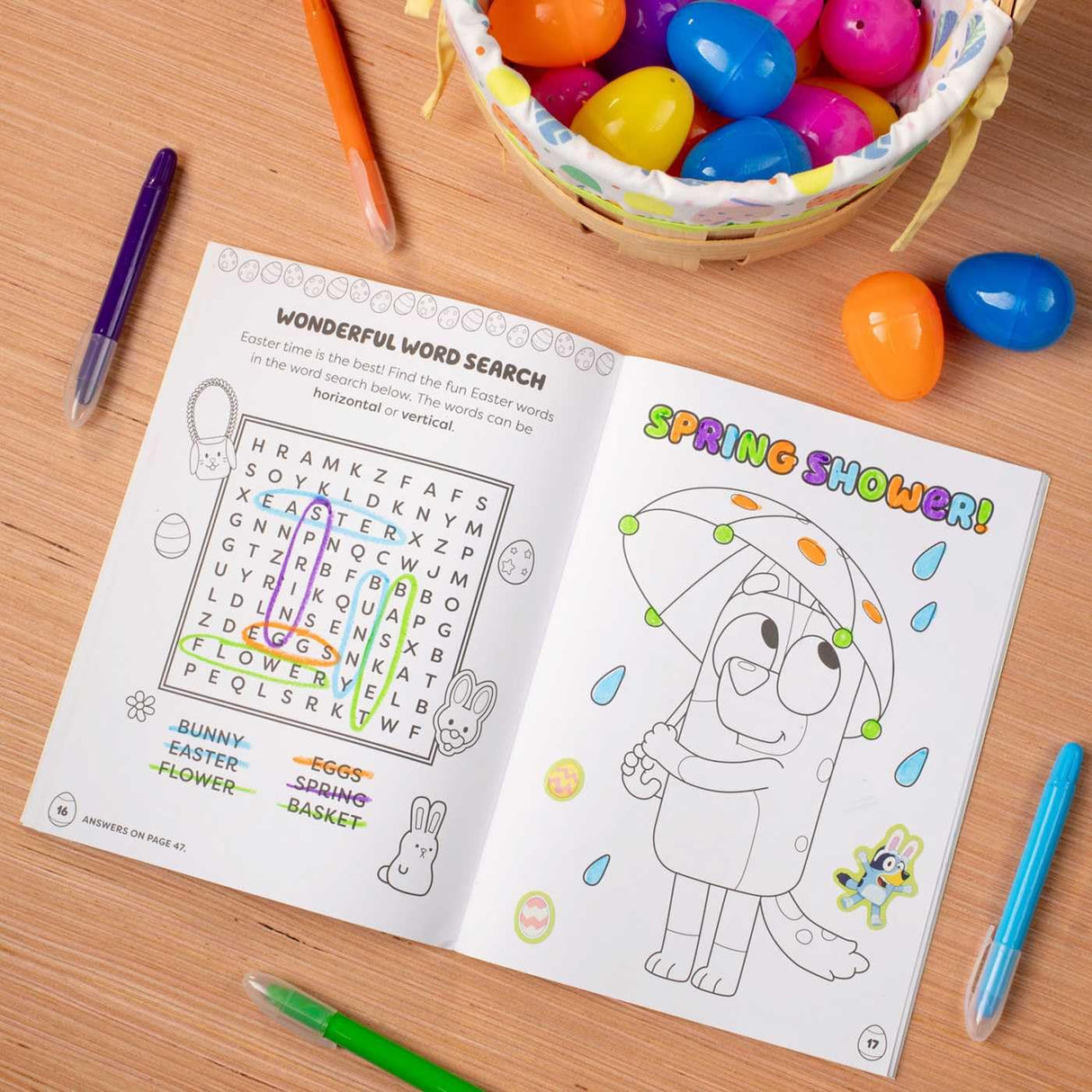 Colortivity: Happy Easter Bluey! activity pad open to word search and coloring page with colorful eggs and pens nearby