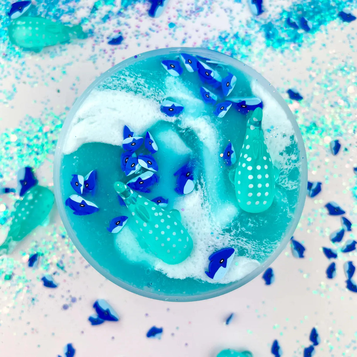 Gummy Shark Jelly Creme Slime with swirling blue and white colors, shark fimo slices, and whale shark charms.