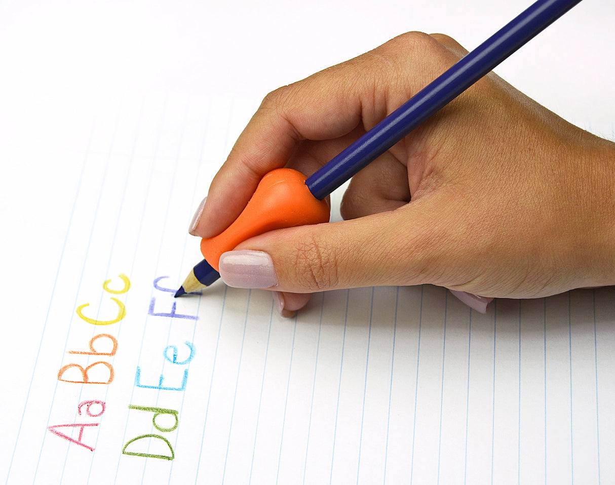 Hand holding pencil with Original Pencil Grip in orange, writing colorful alphabet letters on lined paper.