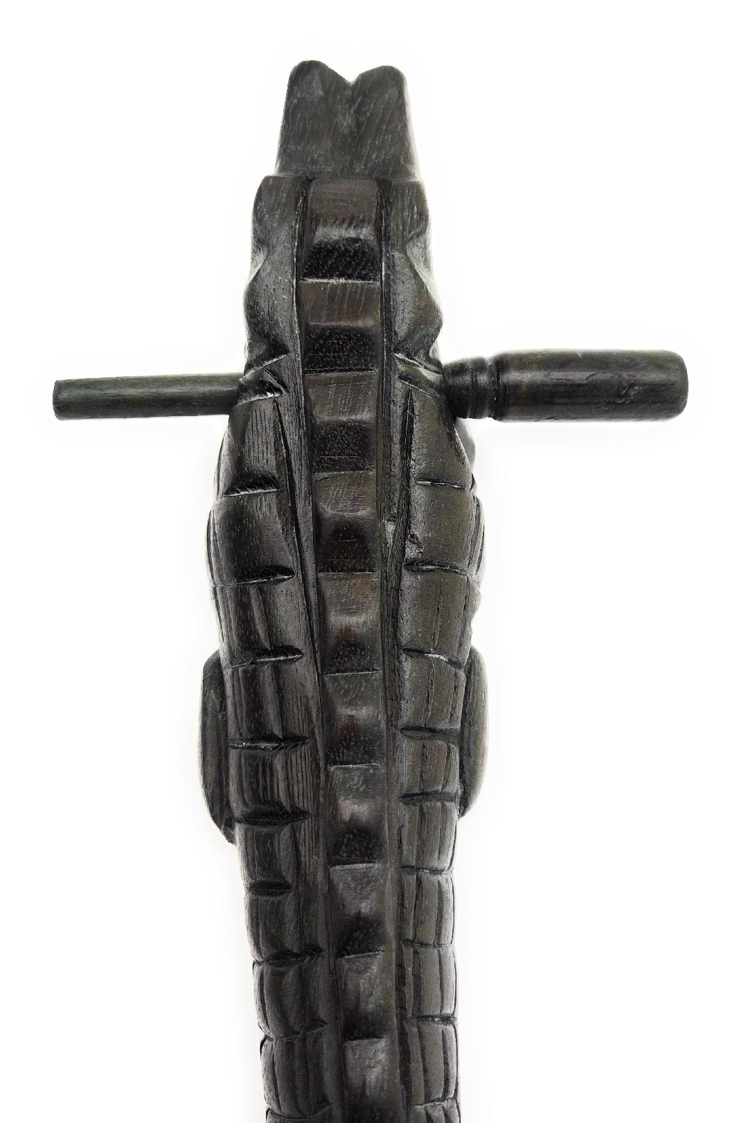 Wooden Croaking Alligator showing dark waxed wood with mallet stick used for drum rasp sound effect.
