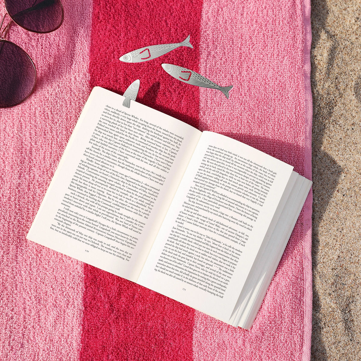Water Marks Bookmarks with fish shaped designs resting on an open book by the water