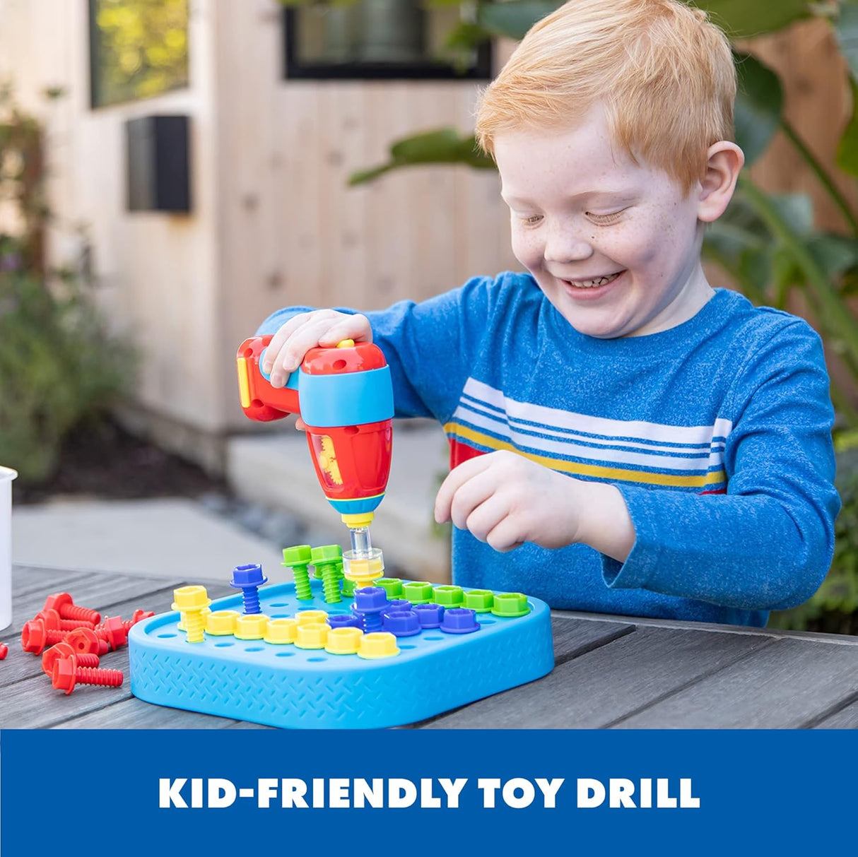 Child using a colorful kid-sized drill to build with vibrant bolts on a blue activity board outdoors