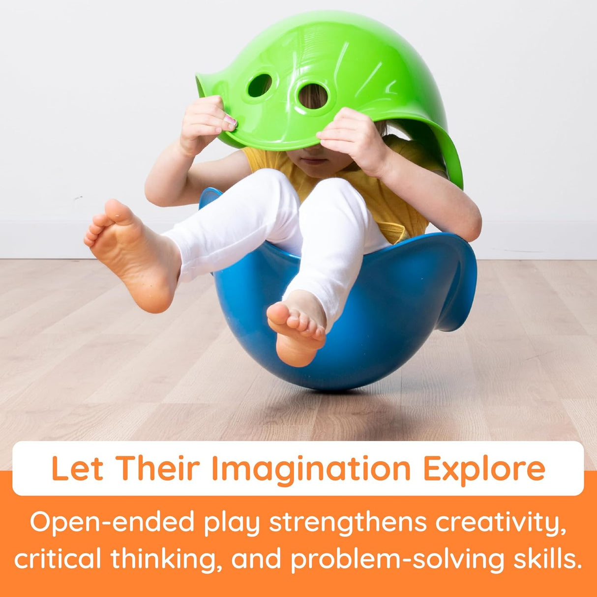 Child playing in blue Bilibo toy bowl wearing green helmet, encouraging imaginative and active open-ended play.
