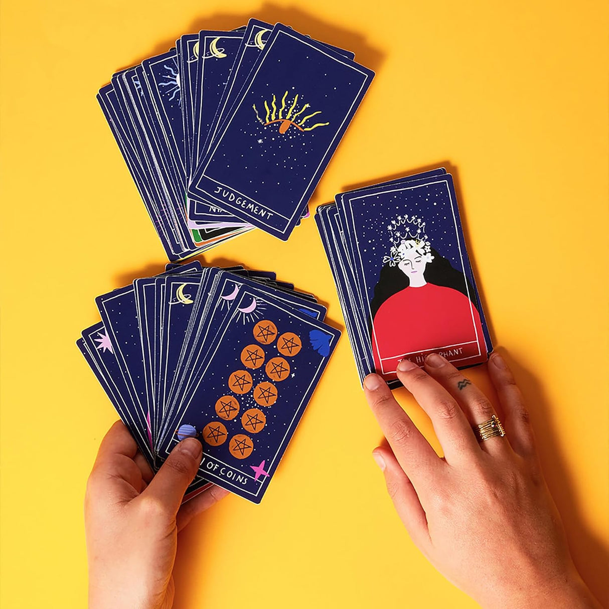 Hands holding vibrant Dream Tarot Cards with detailed, colorful illustrations on a bright yellow background