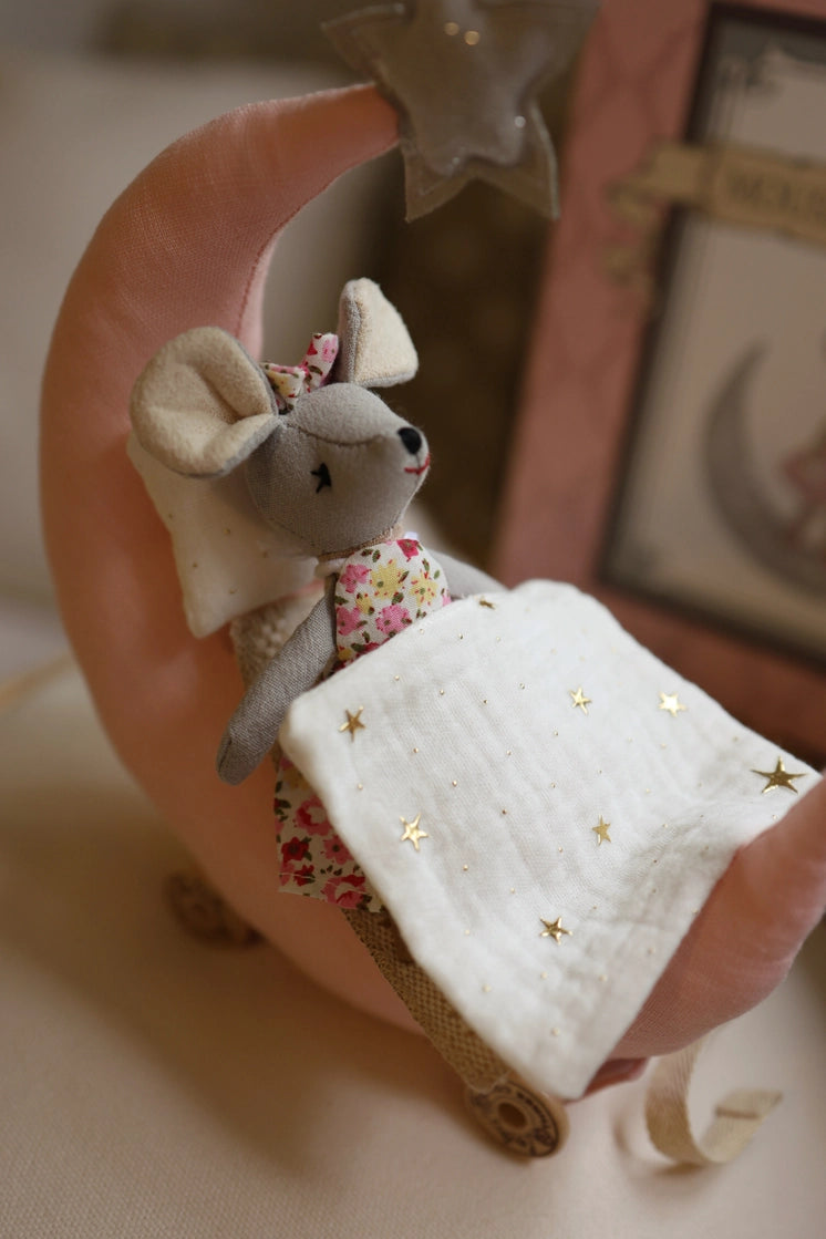 Soft plush mouse tucked into a crescent moon bed with a white starry blanket, peaceful and cozy for bedtime.