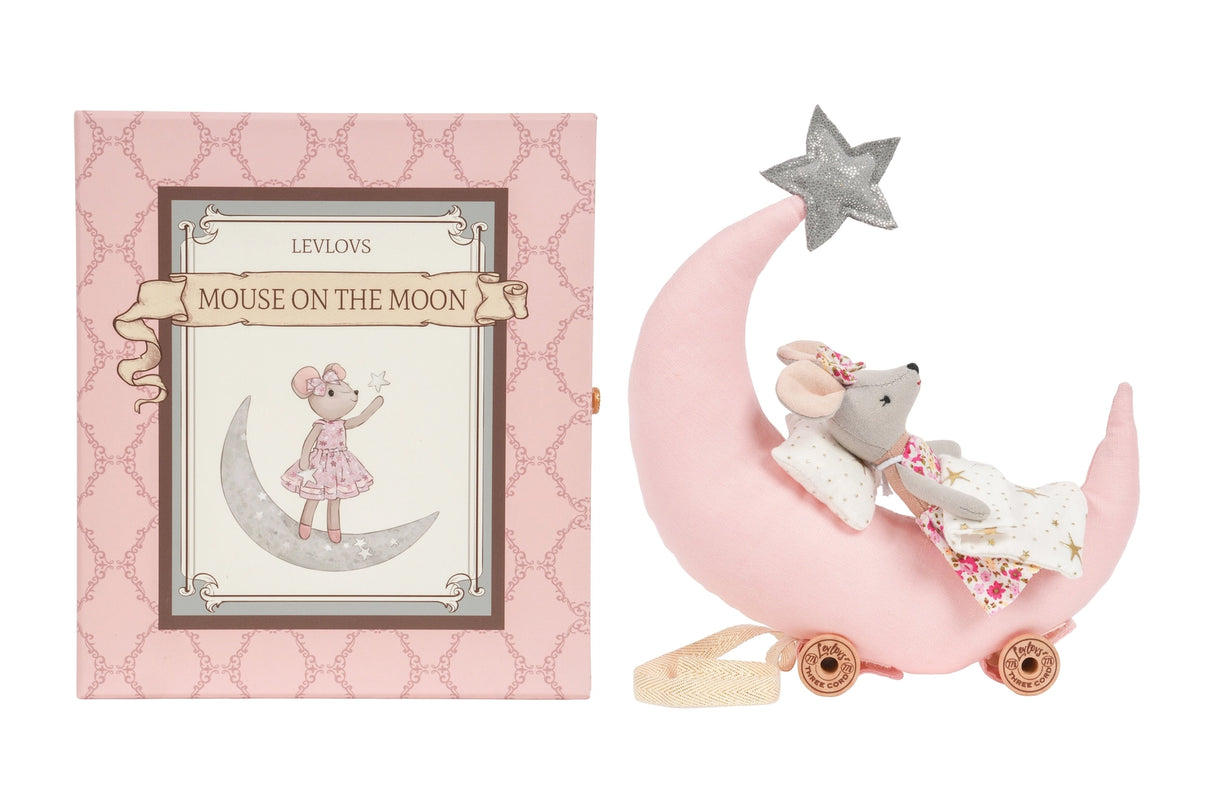 Soft plush mouse lying on a pink crescent moon bed with a silver star on top and a decorative box nearby
