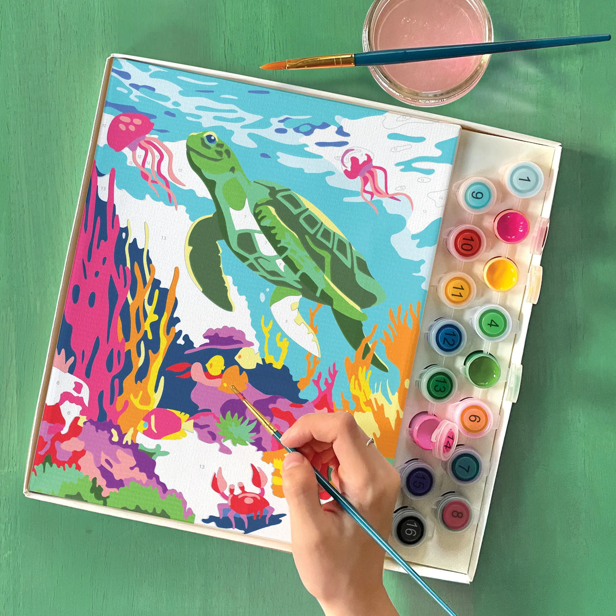 Hand painting vibrant ocean scene with sea turtle and colorful coral using paint by numbers kit for kids aged eight and above