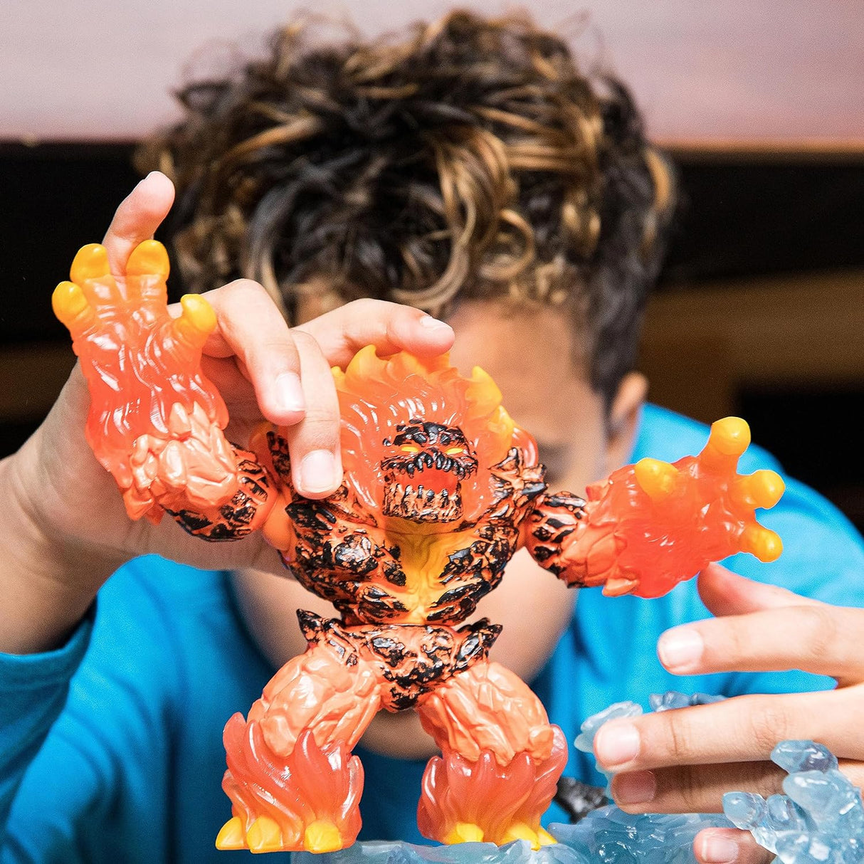 Child playing with Eldrador Creatures | Lava Smasher fiery toy figure with movable arms, torso, and jaw.
