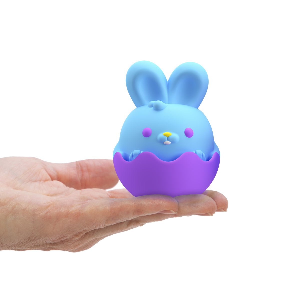Hand holding a blue bunny in a purple eggshell stand, soft squeezable toy NeeDoh Easter Friend.