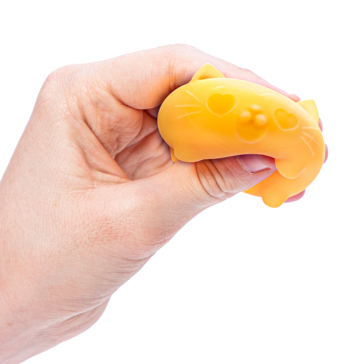 Hand squeezing yellow NeeDoh Teenie Cool Cats stress toy with heart-shaped eyes and cat face details.