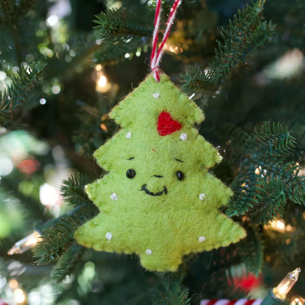 Smiling Christmas Tree Felt Ornament hanging on tree, handmade colorful sheep wool decoration from Nepal.
