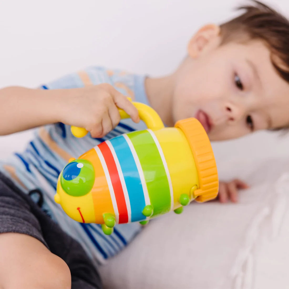 Young child holding colorful Flashlight Giddy Buggy with sturdy handle and bright light for nighttime fun.