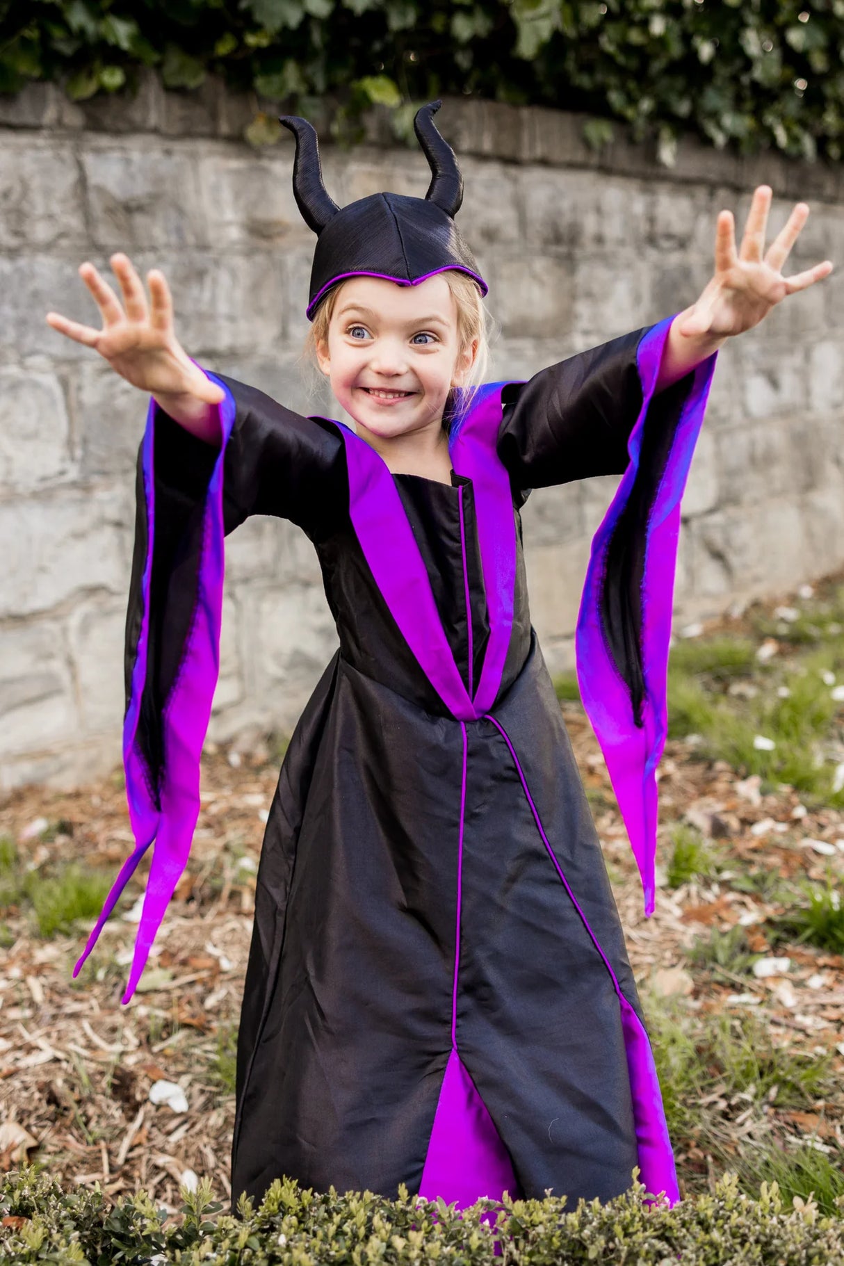 Young girl wearing Villain Princess Dress & Headpiece size 5-6 in black and purple with long bell sleeves.