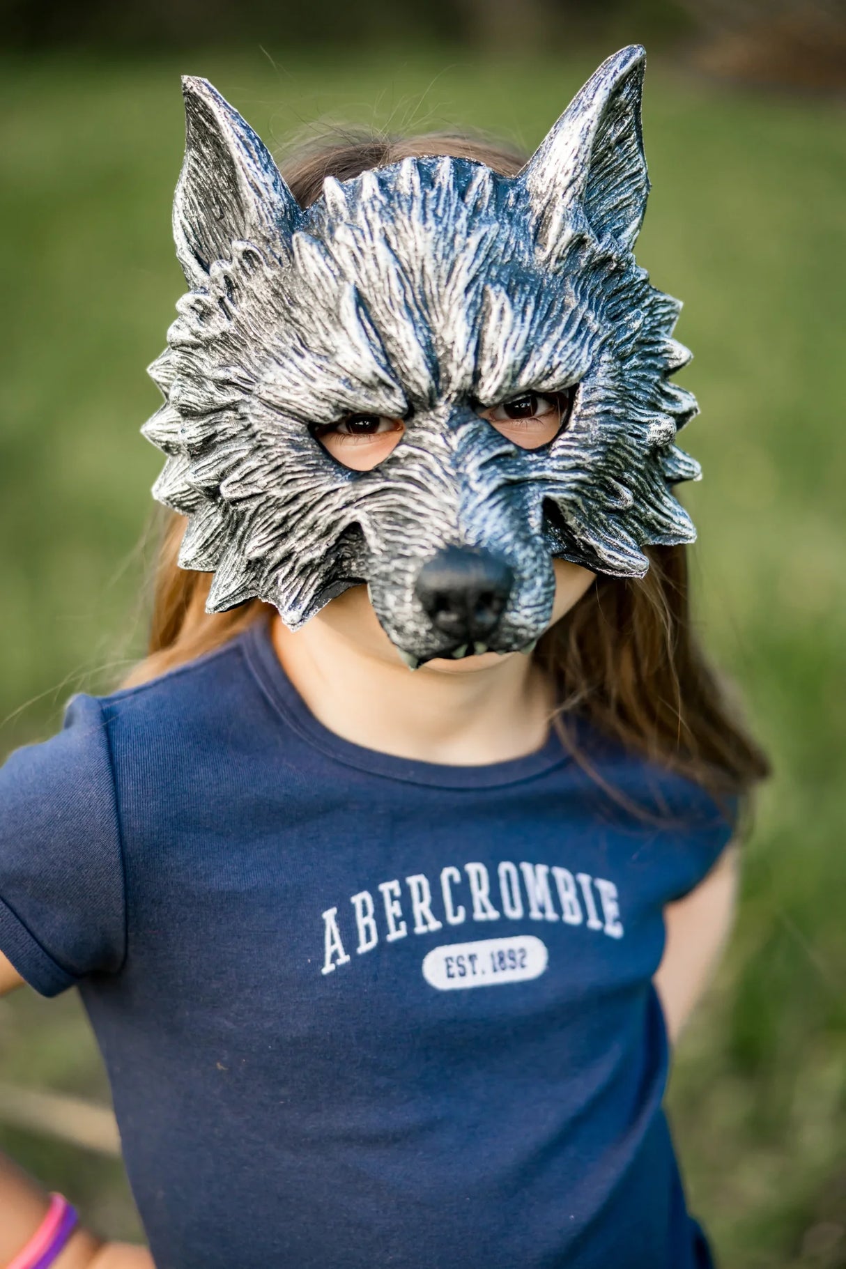 Child wearing a detailed rubberized Werewolf Mask with realistic fur texture and adjustable strap outdoors