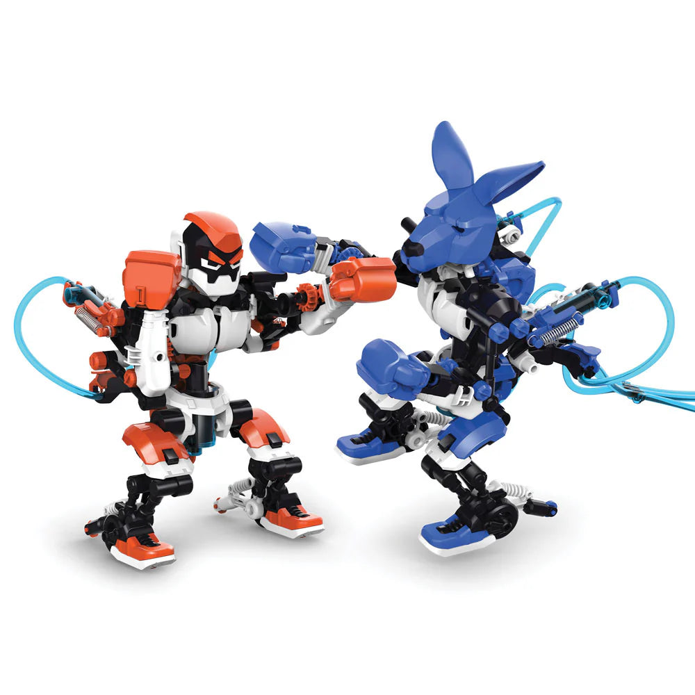 Two colorful hydraulic boxing robots face off in a playful fighting stance against a white background