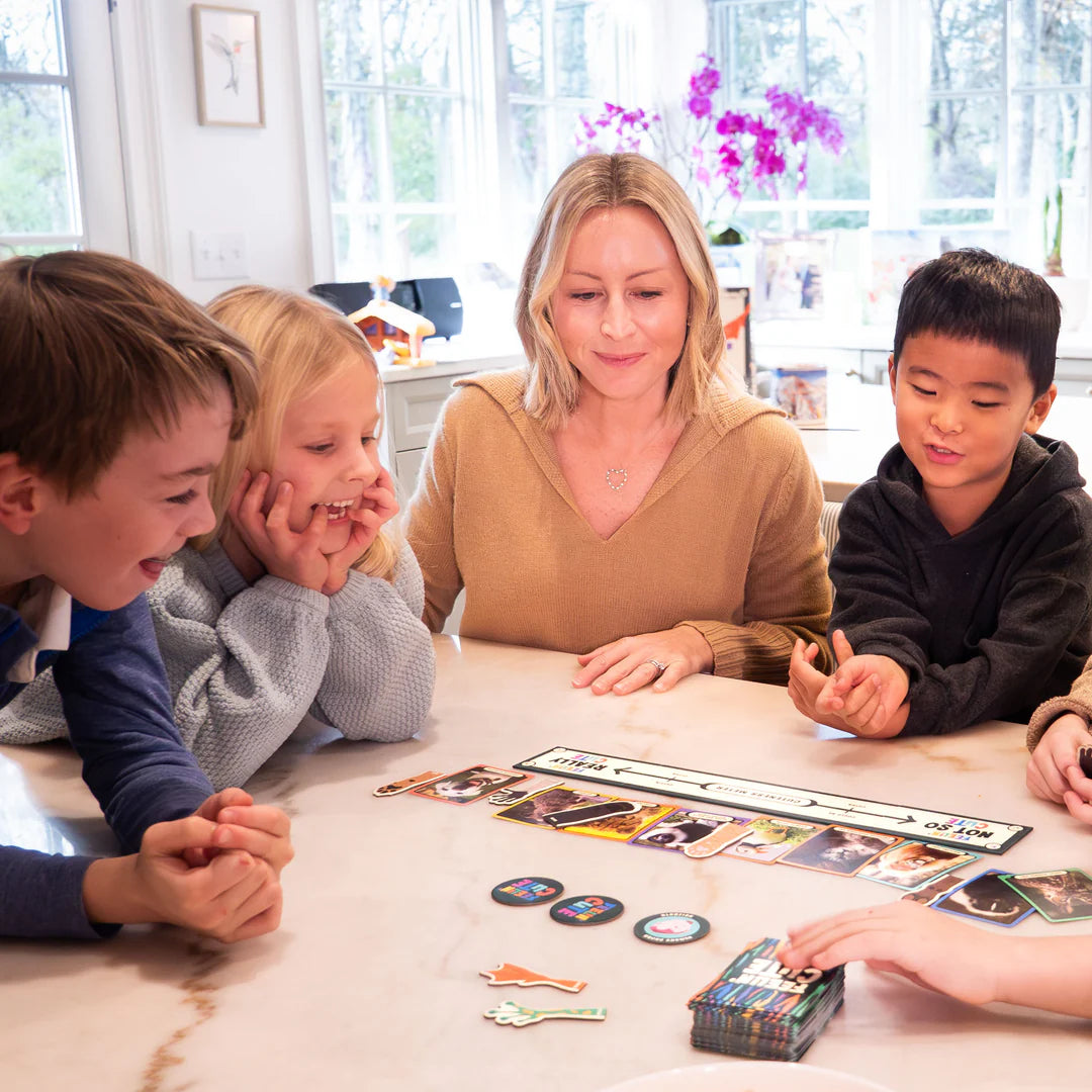Family playing the "Feelin' Cute" card game around a table, enjoying a fun and friendly game time together.
