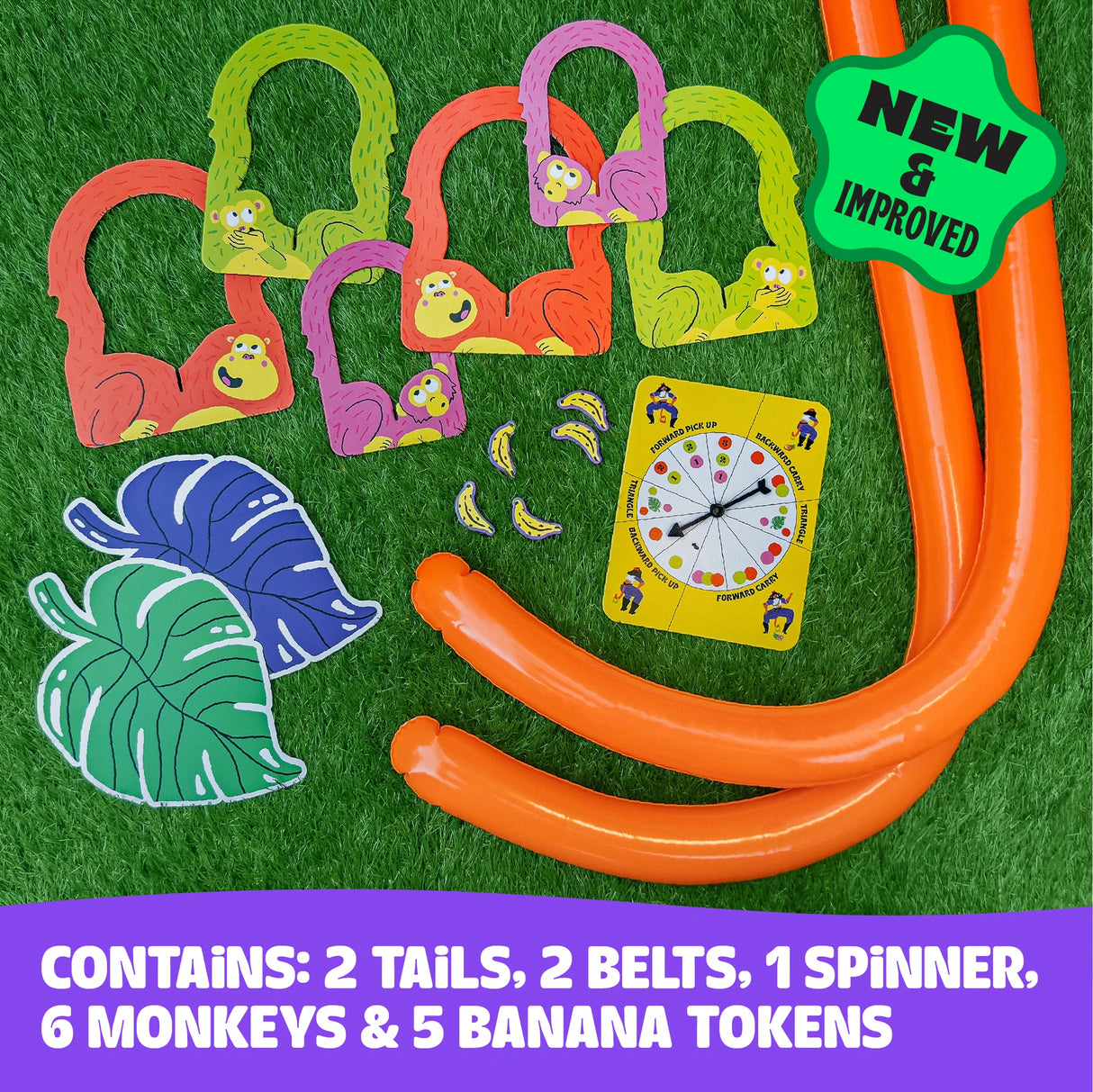 It's Bananas! game set with tails, belts, spinner, tokens, and monkey accessories laid out on green grass.